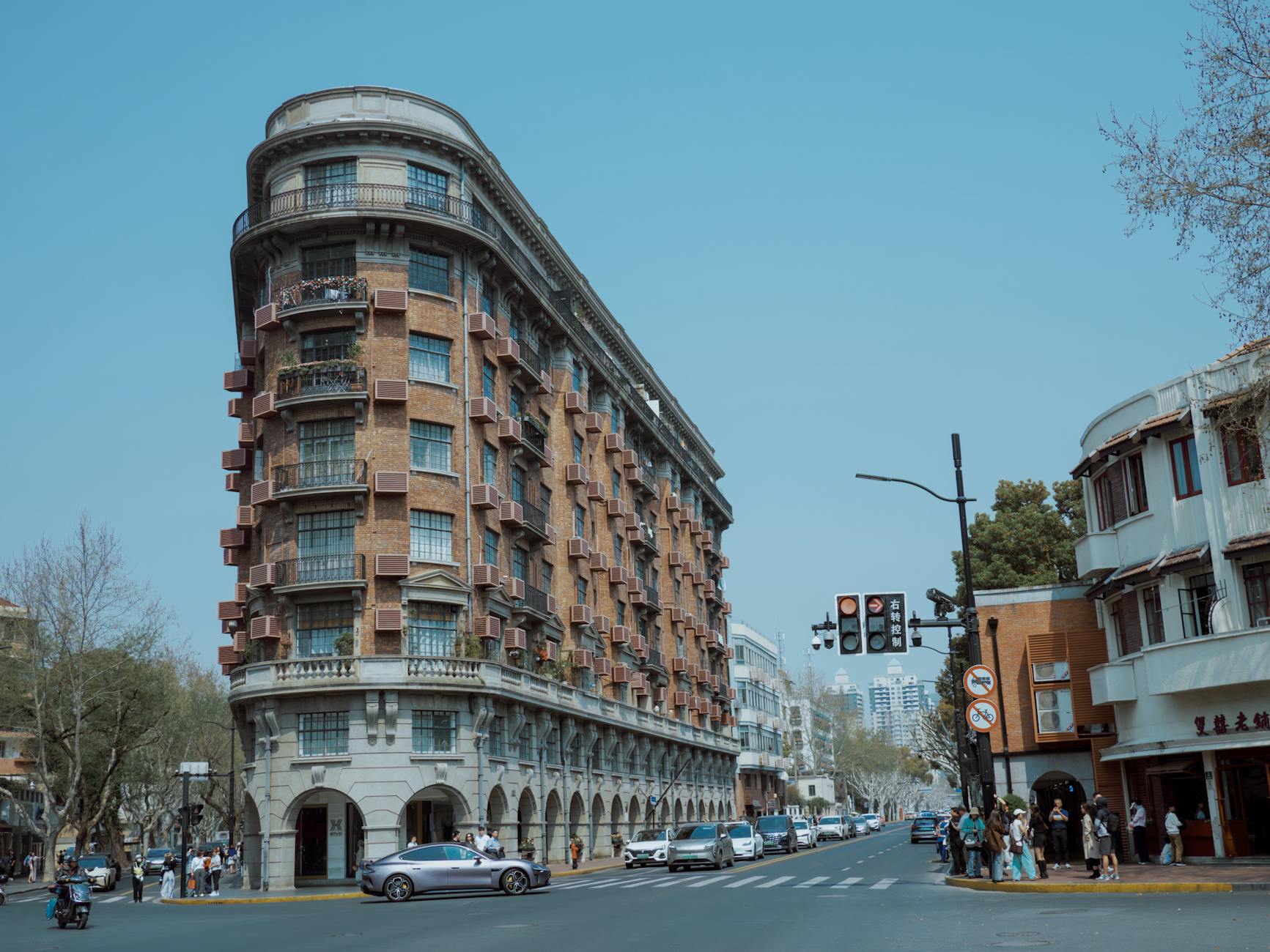 Tree-lined street with cafes in Shanghai's French Concession neighborhood — a popular area to stay in Shanghai