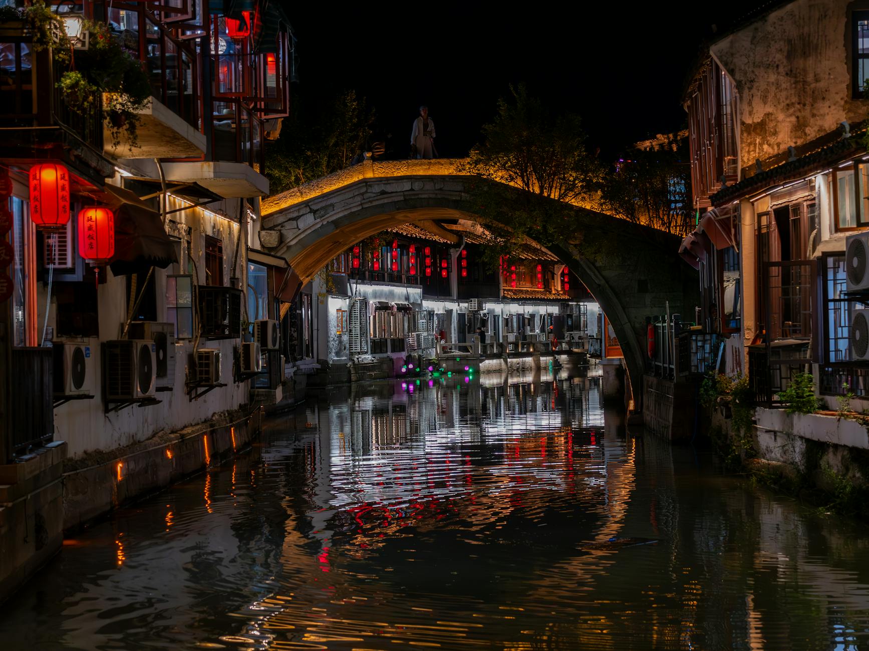 Suzhou canal lit by lanterns at night, the city at its most atmospheric