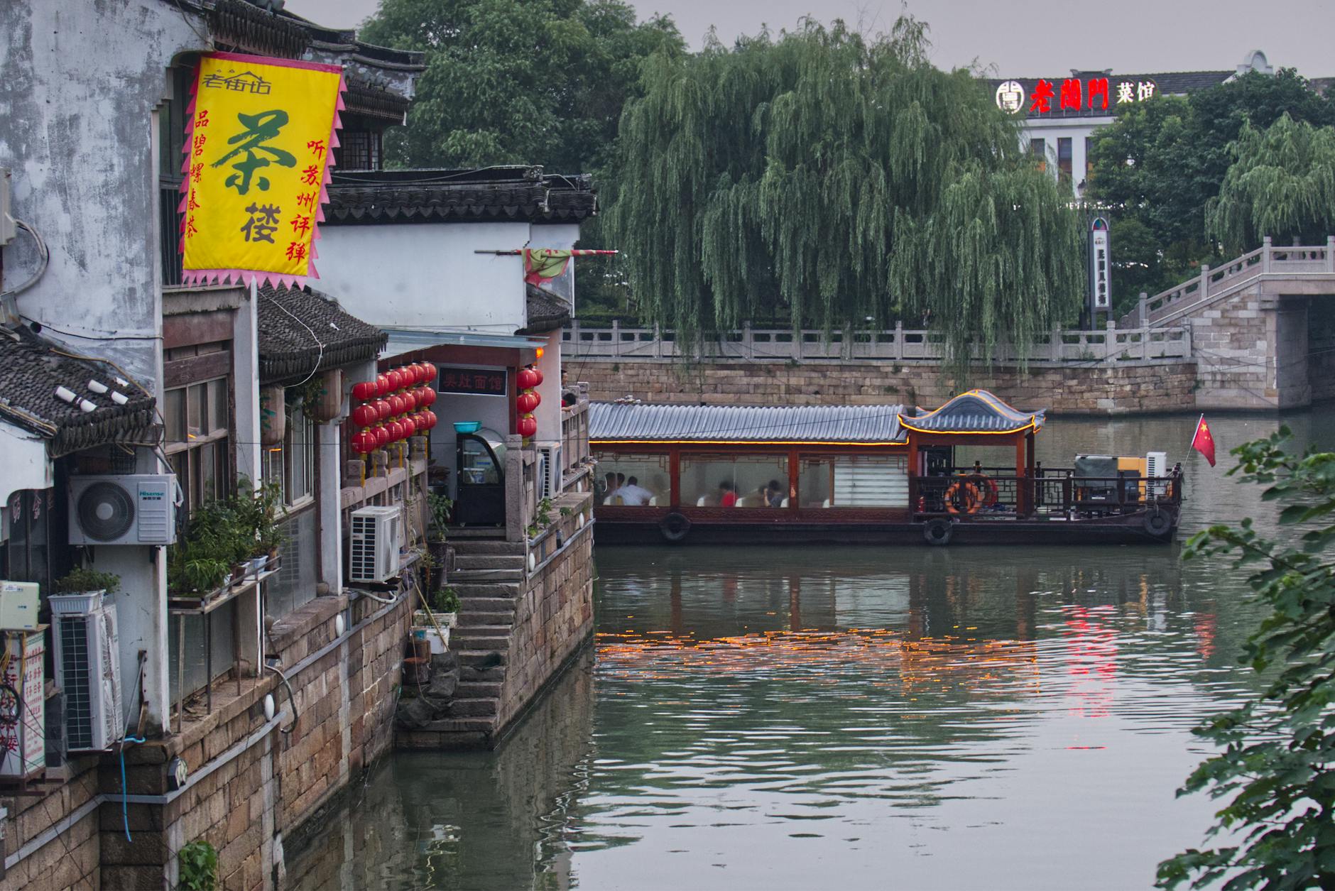 Traditional wooden boat on a Suzhou canal beside Pingjiang Road's old houses