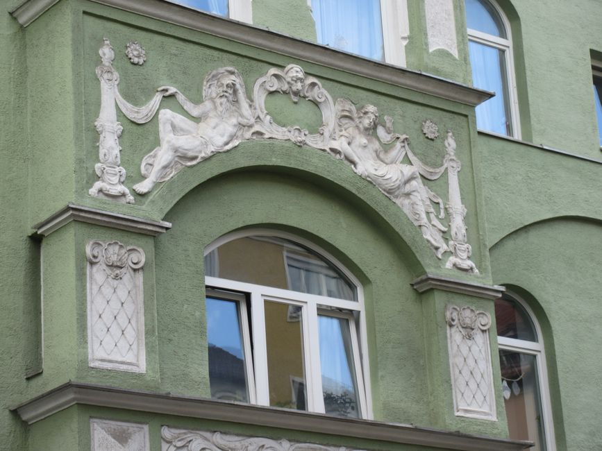 Geometric Art Deco facade ornamentation in green and stone, a signature decorative style
