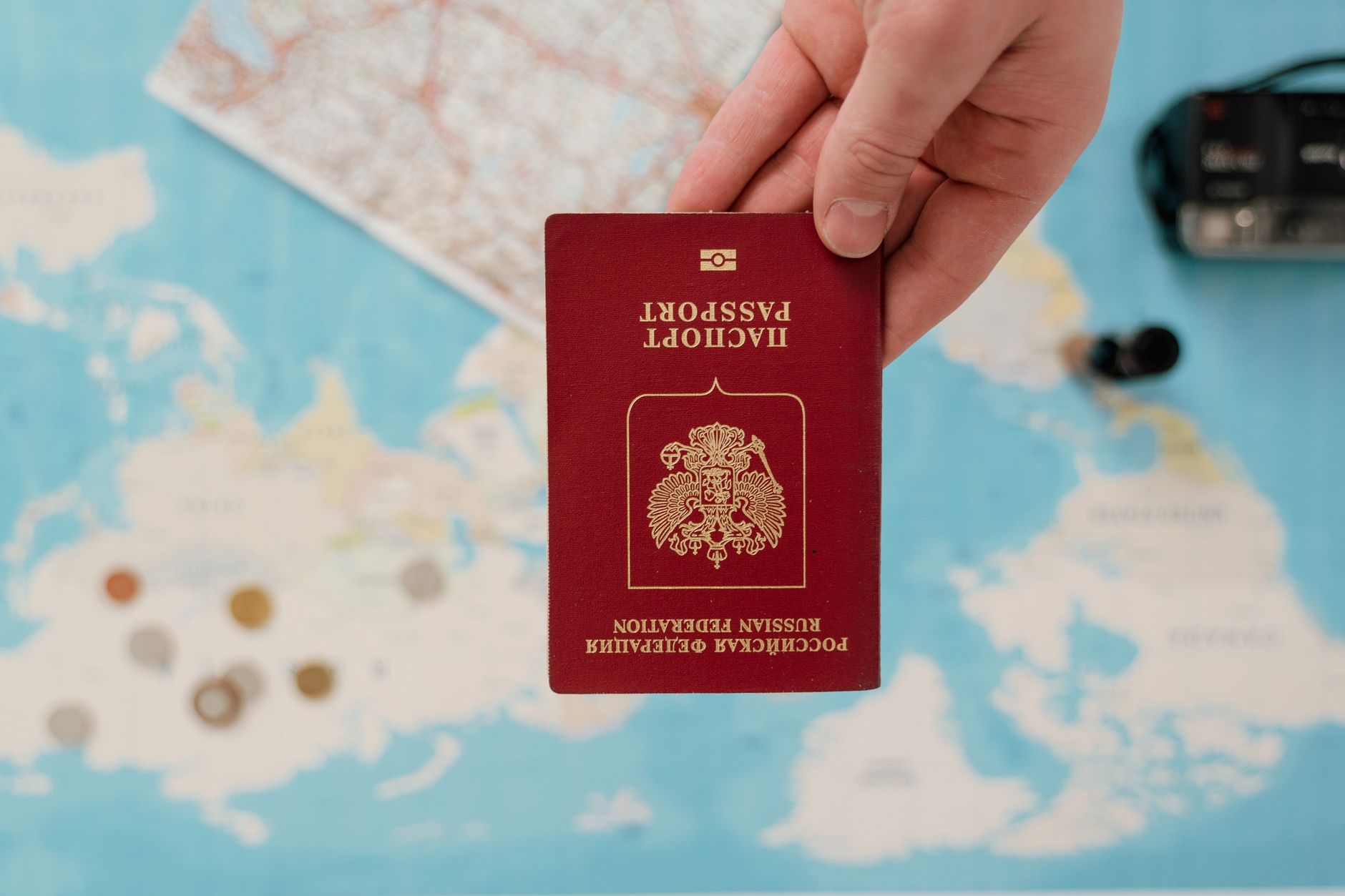 Hand holding a passport over a map while preparing a China tourist visa application