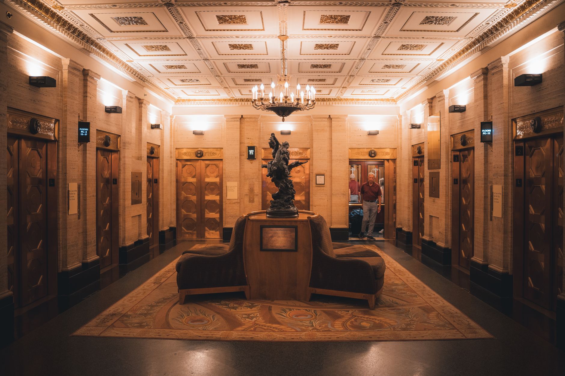 An Art Deco lift lobby with chandeliers, the architectural style of the heritage luxury hotels on the Shanghai Bund