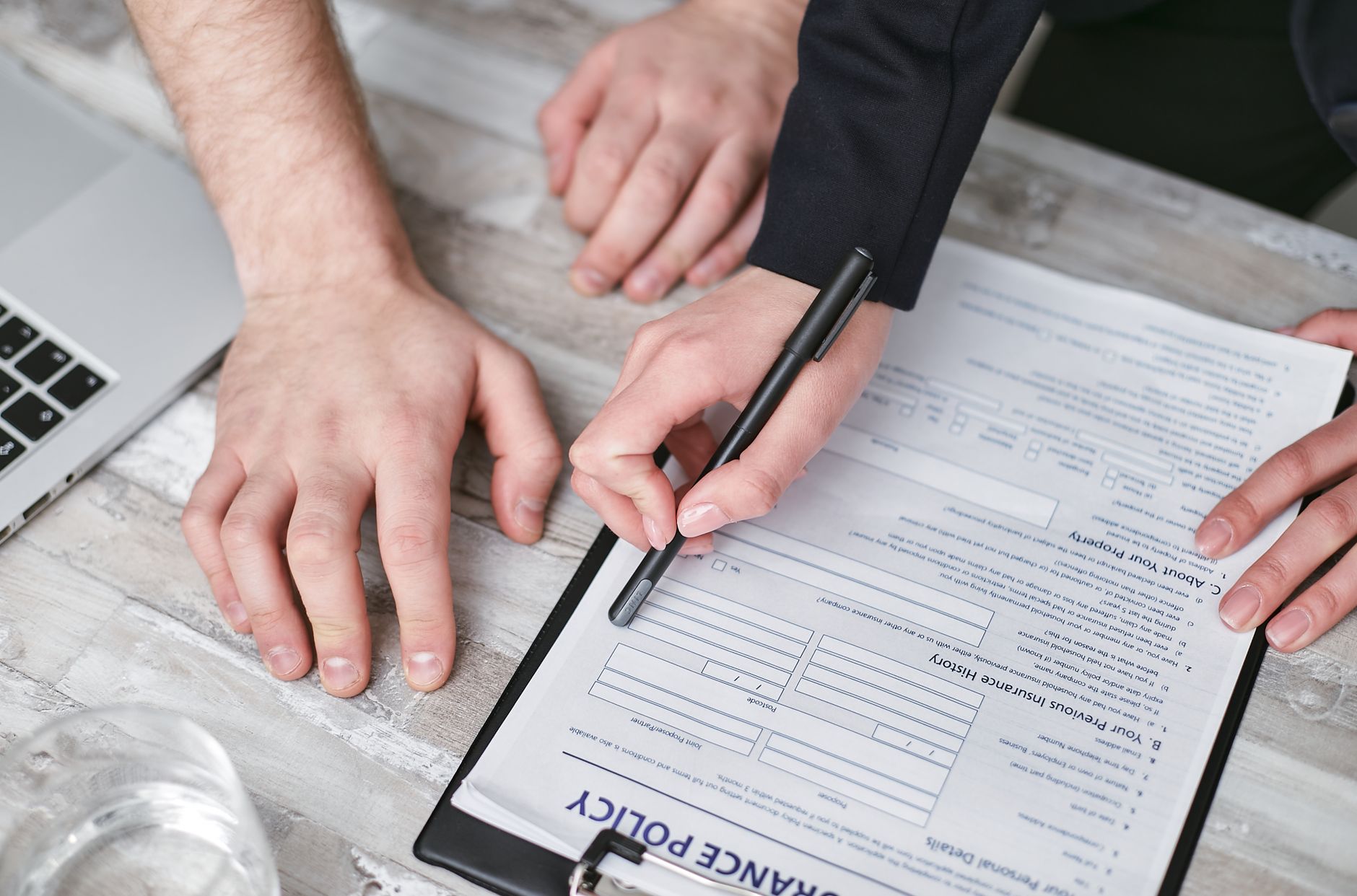 Two people reading through an insurance policy document before signing, comparing cover for a trip to China