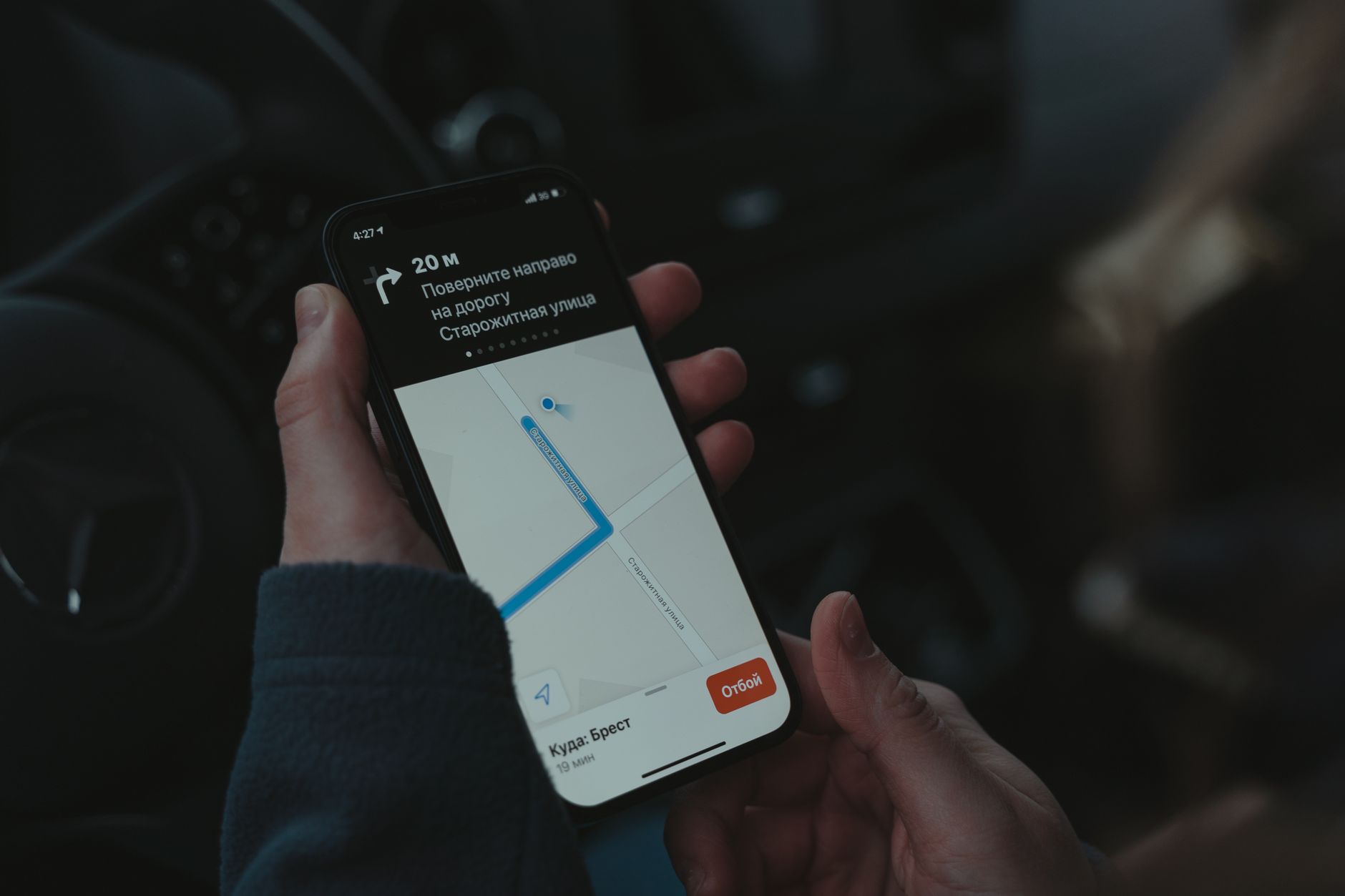 A ride-hailing navigation app running on a phone mounted inside a car dashboard