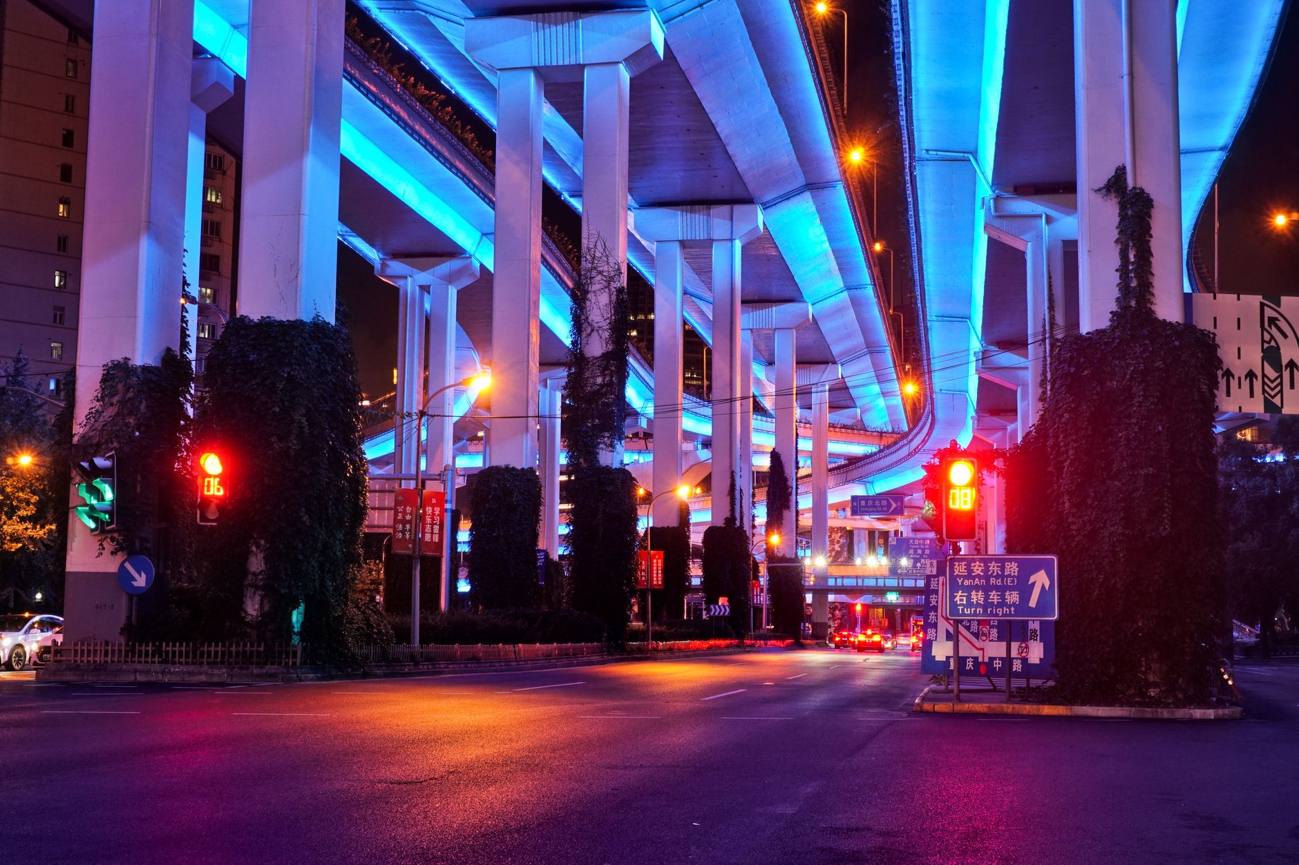 Traffic moving under Shanghai's illuminated elevated flyovers at night