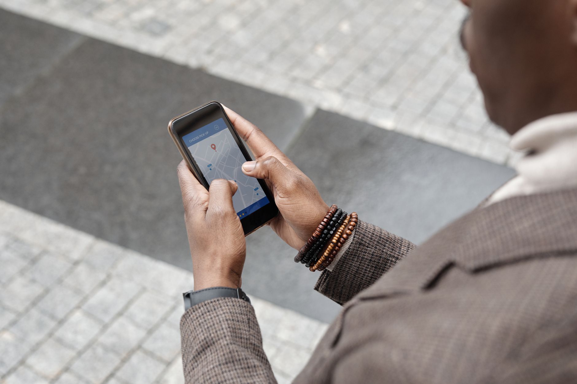 A traveller checking a navigation app on a smartphone on a city street