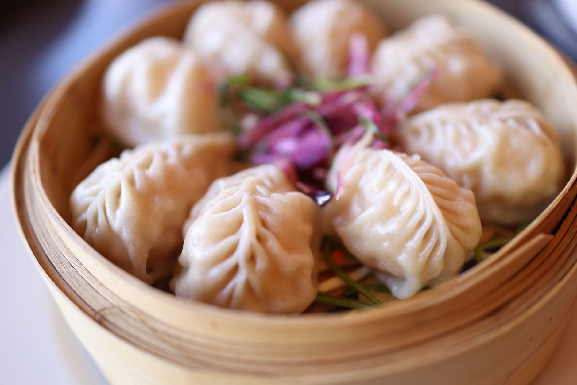 Steamed dumplings in a bamboo basket, the kind of shareable dish that works well for families in Shanghai