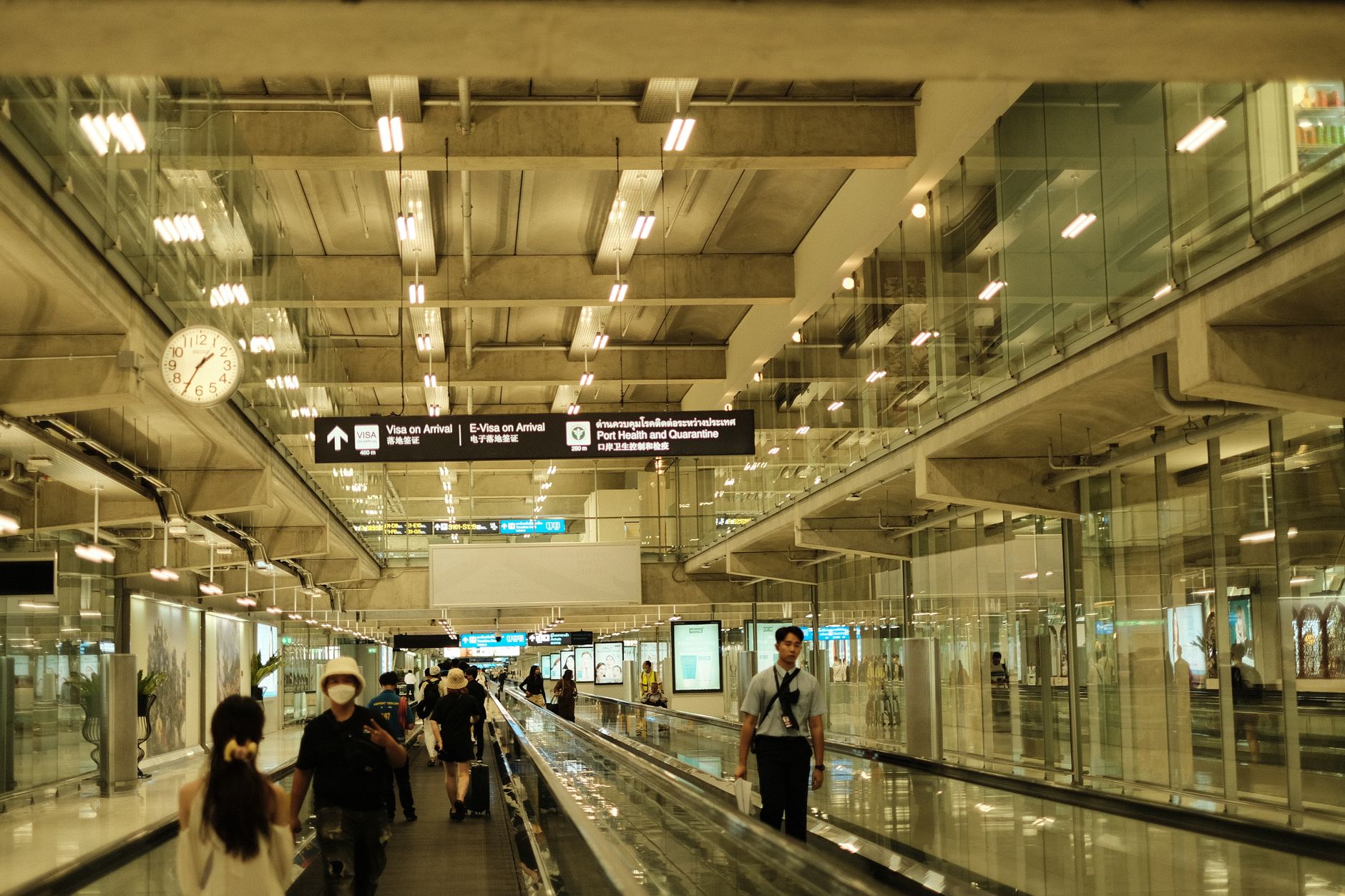 Passengers walking through a bright modern airport terminal after landing on a long-haul flight into Shanghai.