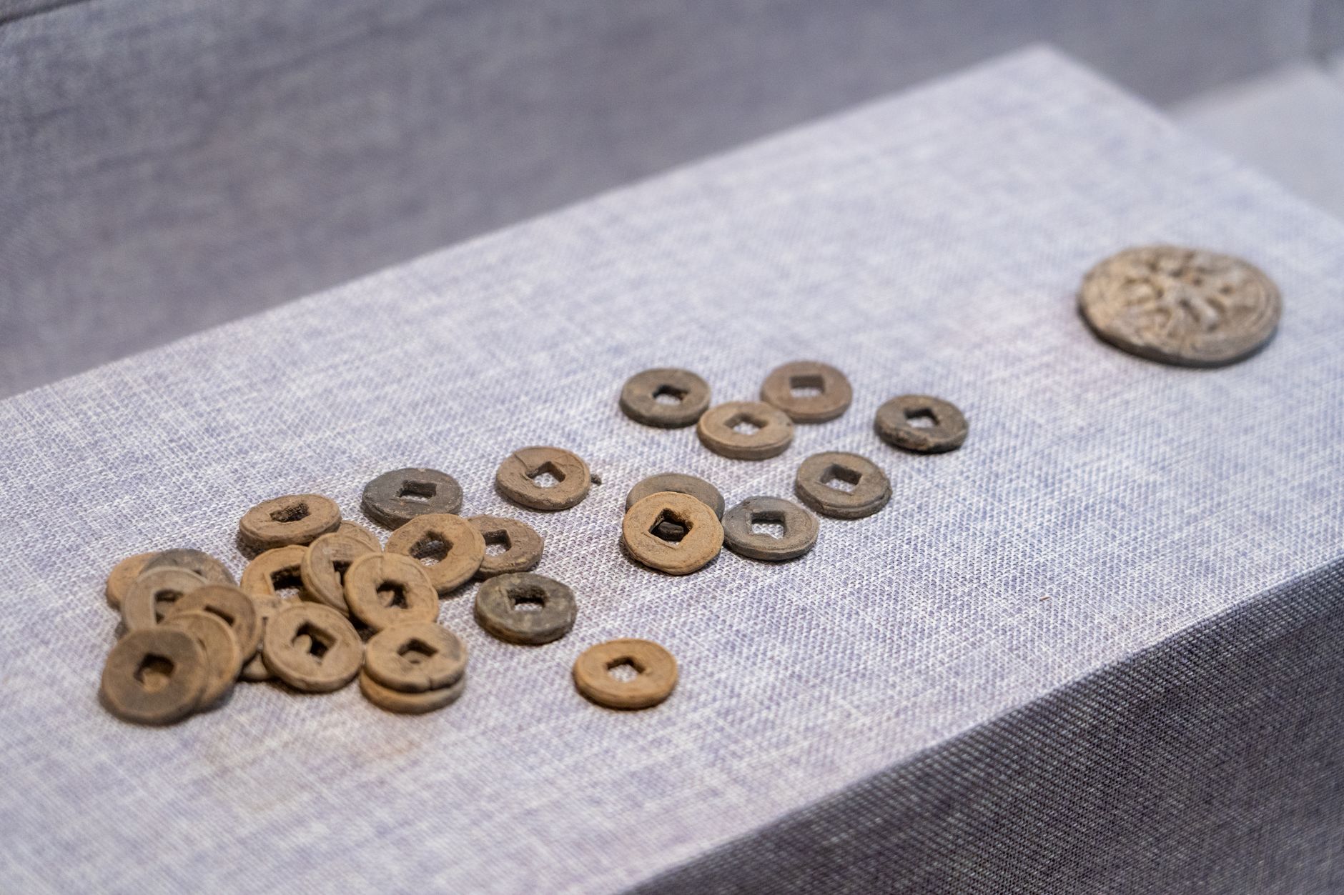 Old Chinese coins and small collectibles laid out on a dealer's table