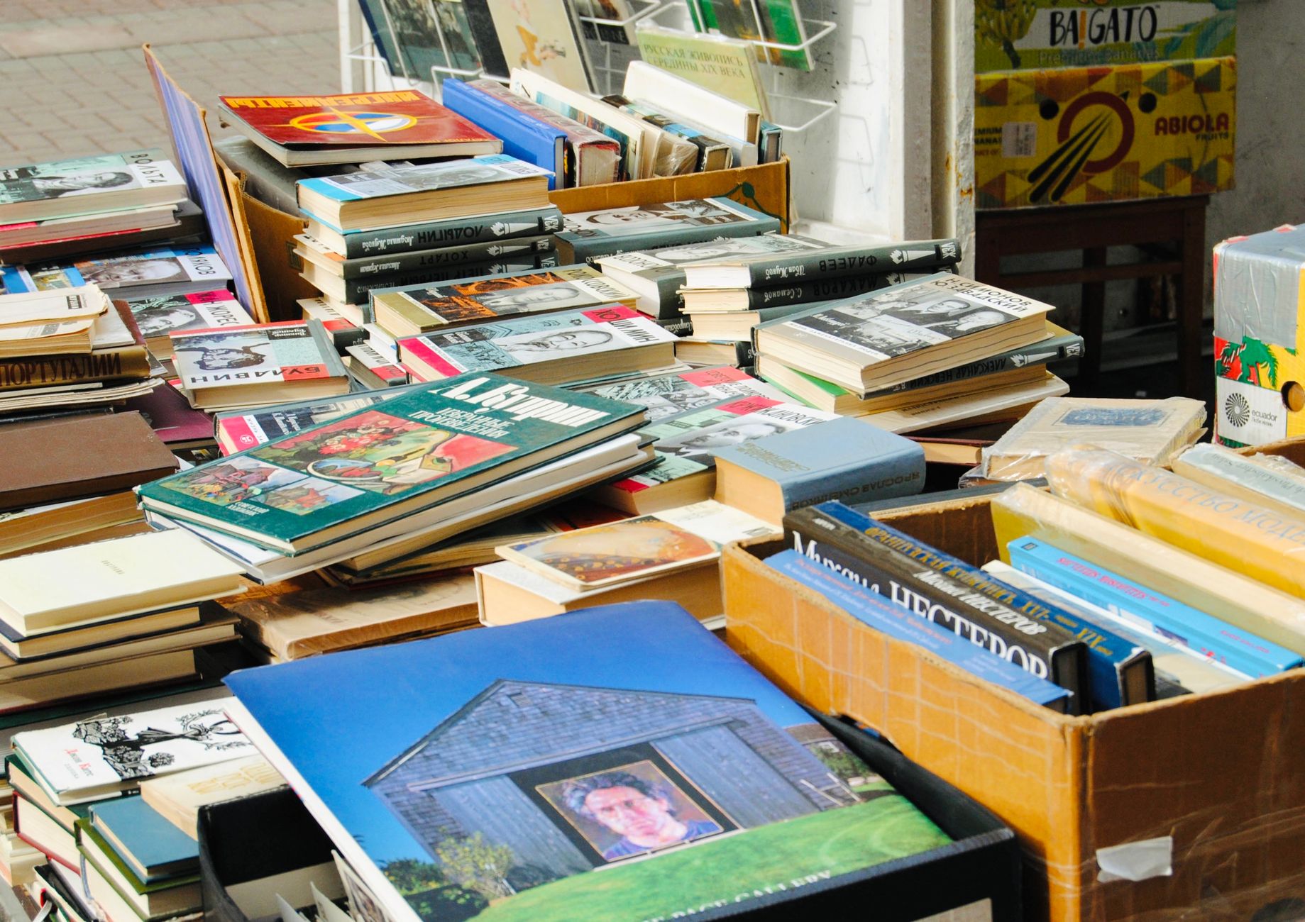Second-hand books stacked on a market table at an early morning book market