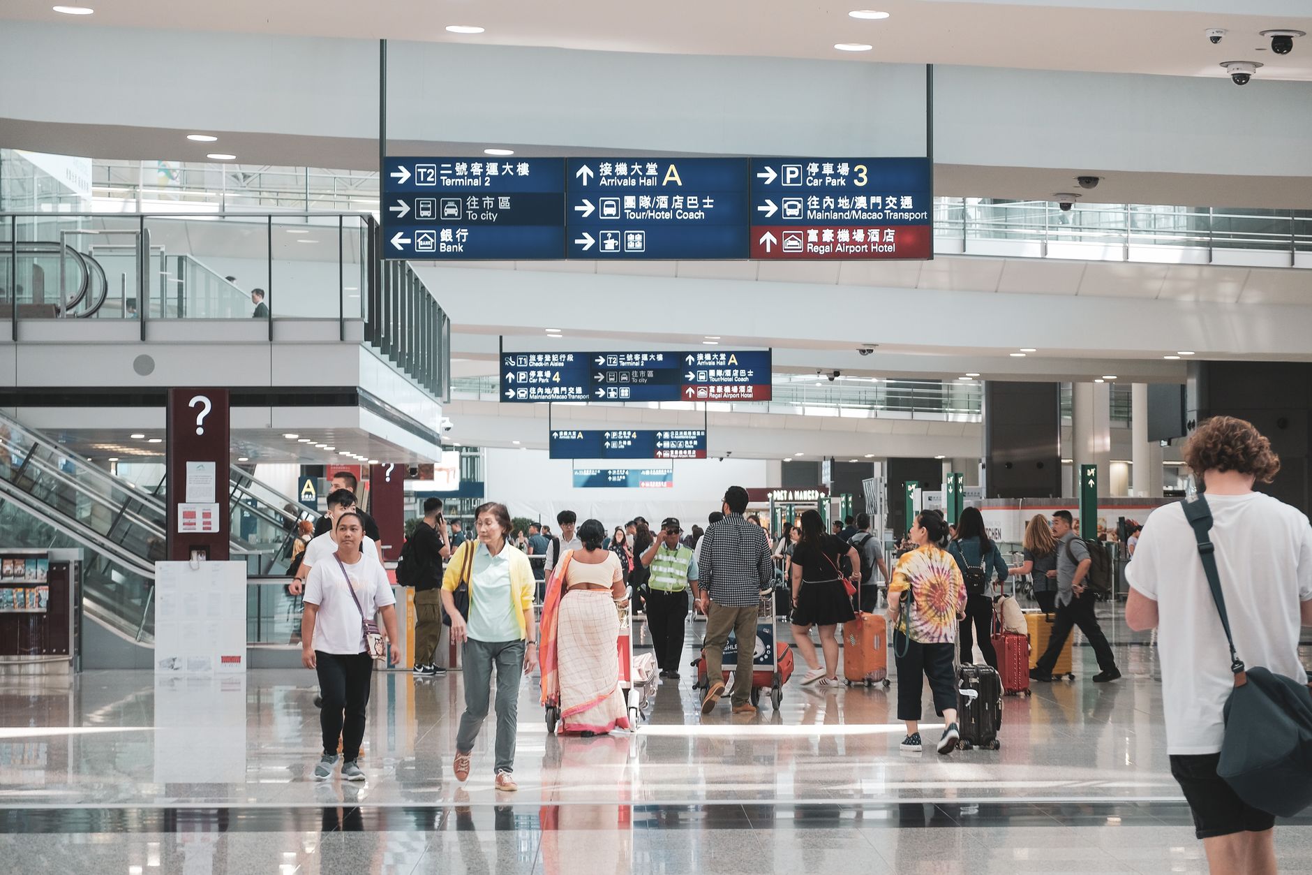 Arriving passengers walking through an Asian airport terminal towards the customs channels