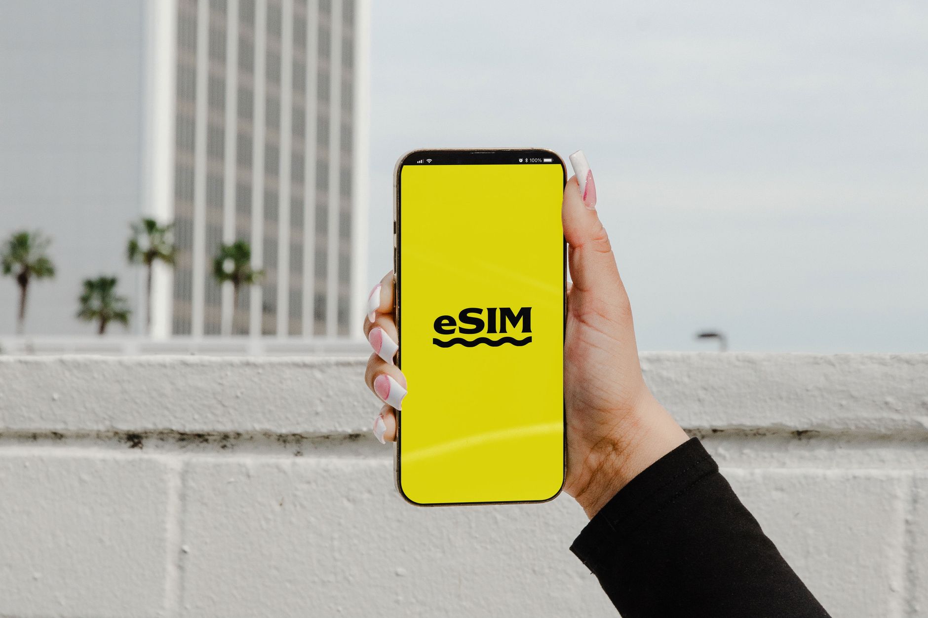A traveller holding a smartphone showing an eSIM profile, the setup most visitors to Shanghai now use instead of a local SIM card