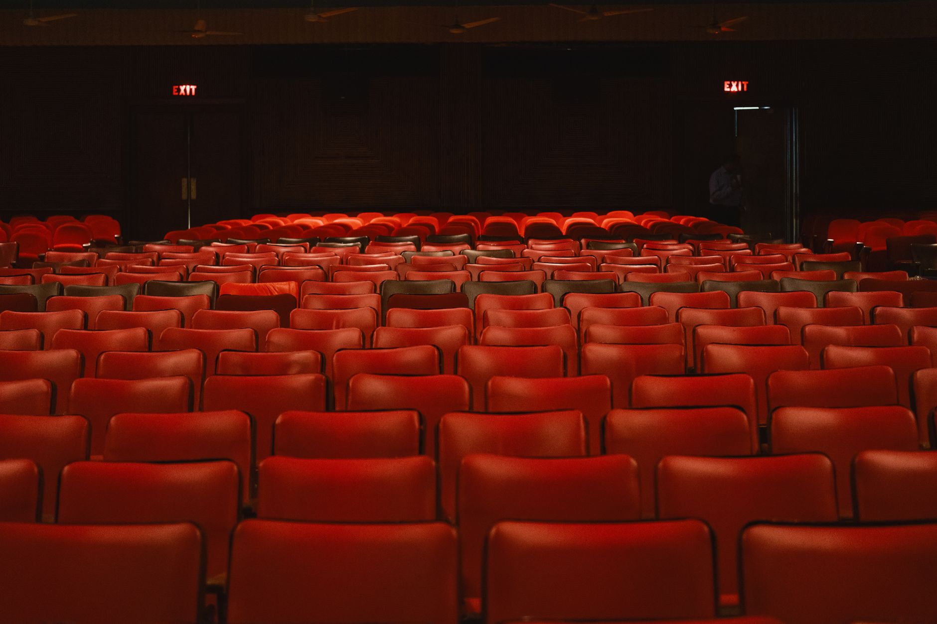 Rows of empty red seats in an old-style cinema auditorium before a screening
