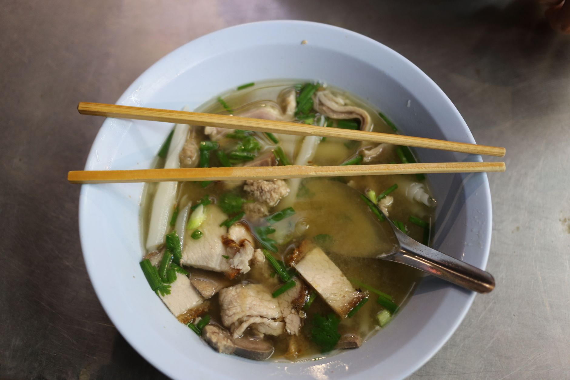 Bowl of pork noodle soup with chopsticks, a staple order on Shanghai food streets