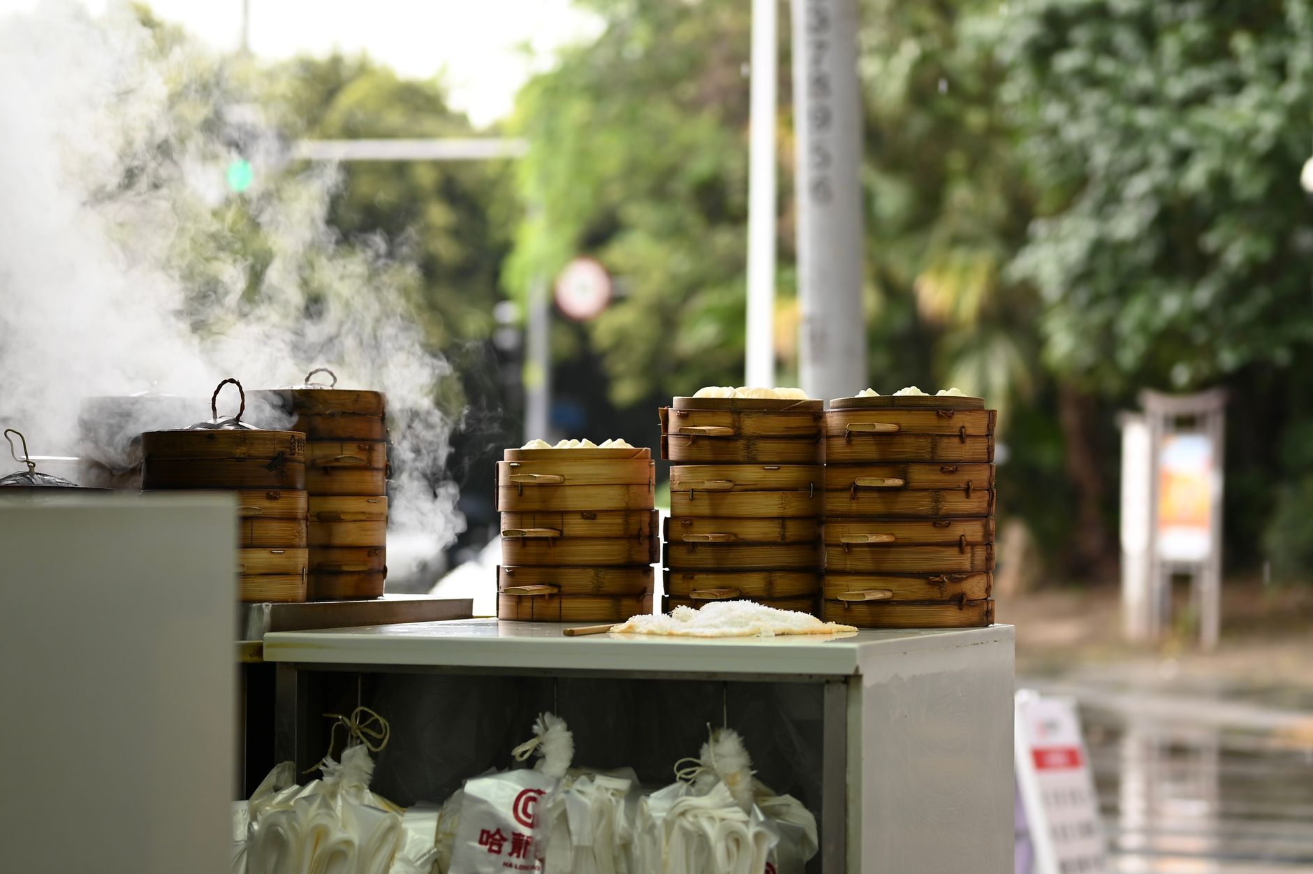Street vendor steaming bamboo baskets of dumplings on a Shanghai food street