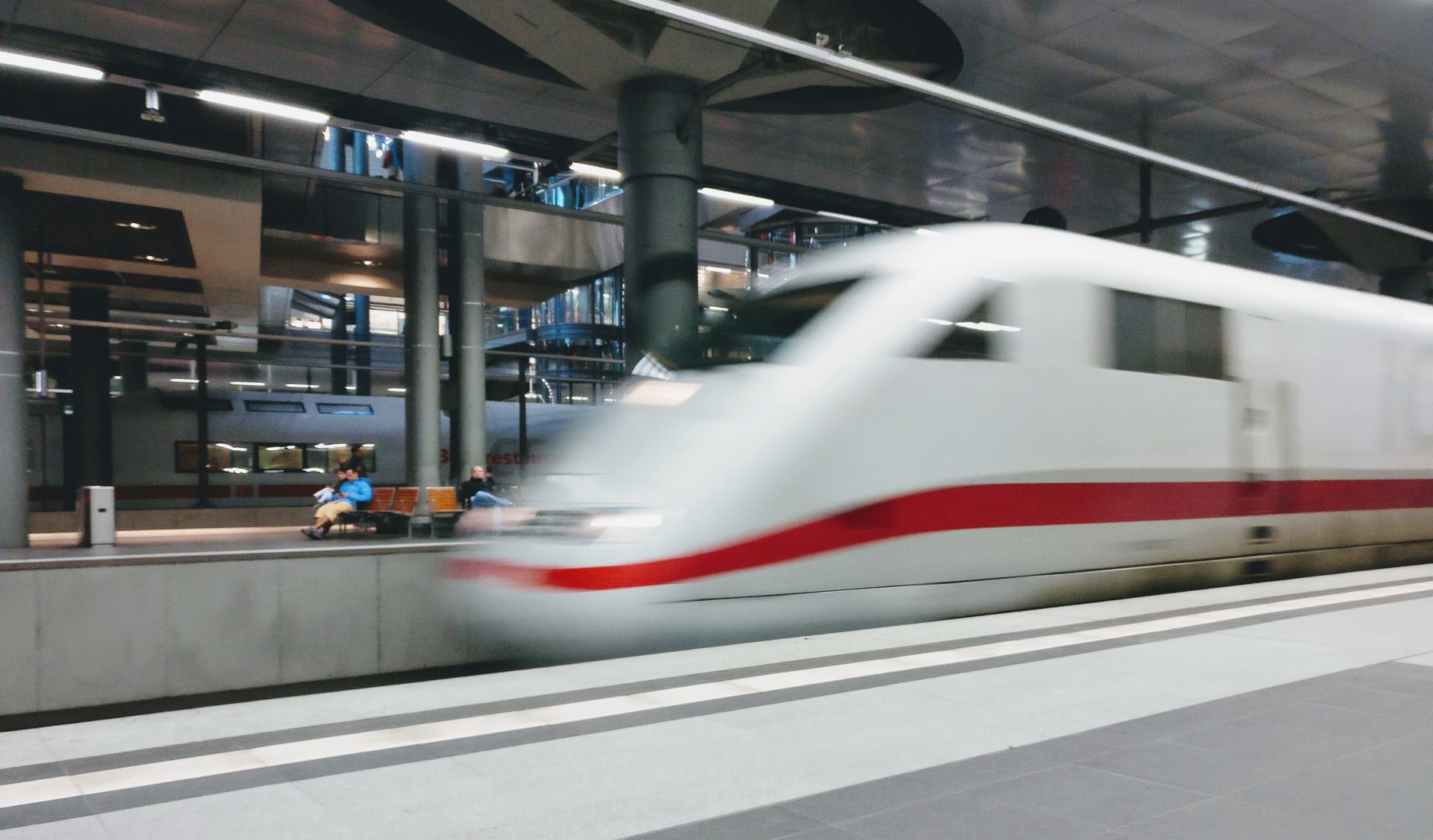 A high-speed train departing a modern urban station platform, the format the Shanghai Maglev uses