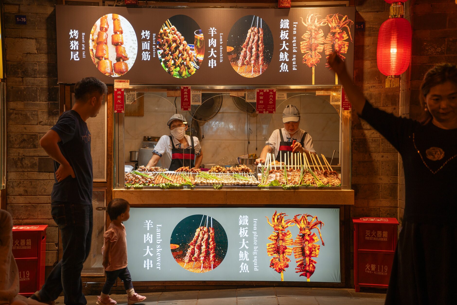 Skewers grilling on a street-food stall at a Chinese night market in the evening