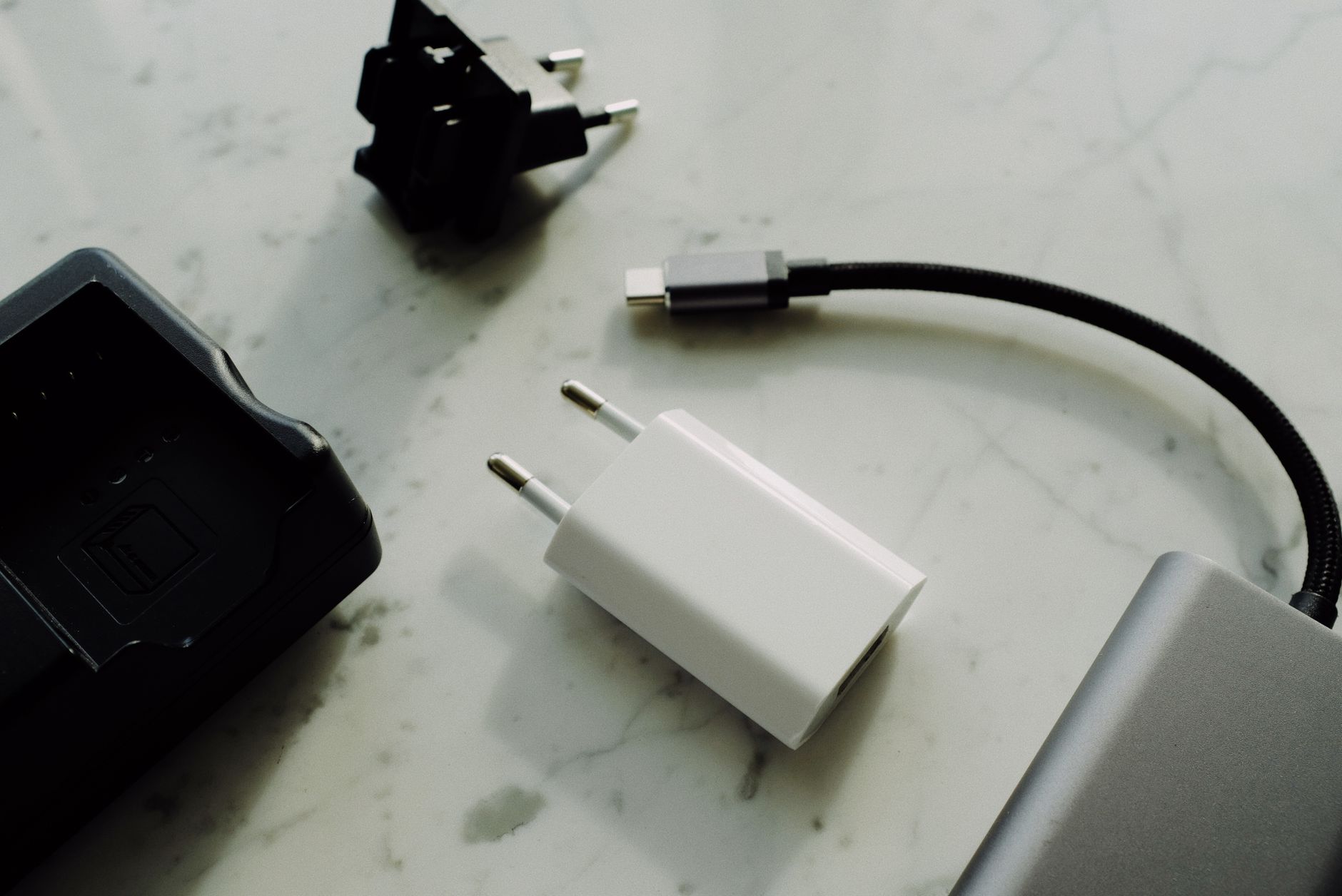 Travel adapters, cables and a power bank laid out for a Shanghai packing list