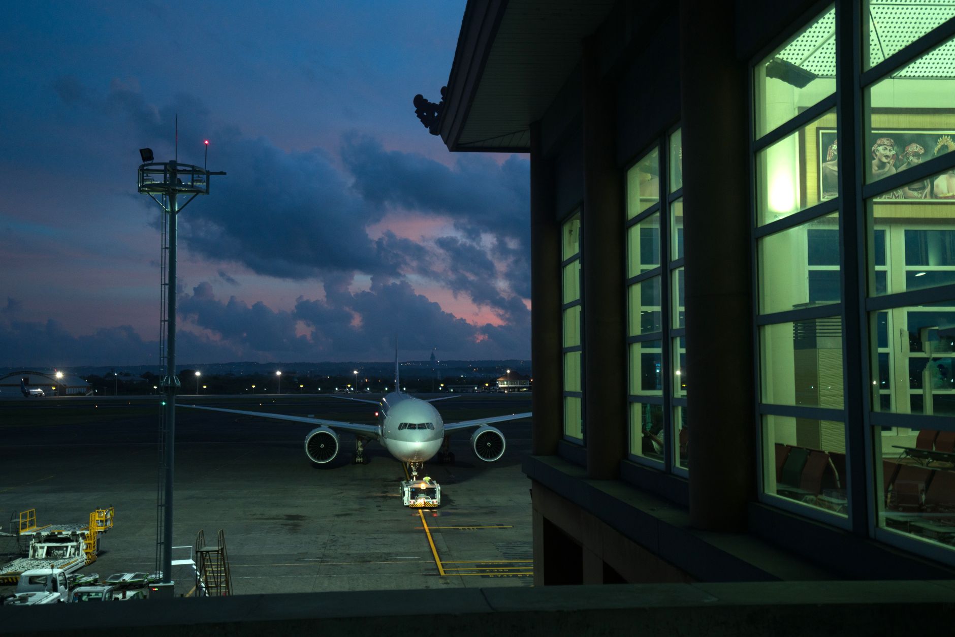 Aircraft parked at an airport terminal gate at night, the scene most transit travellers see arriving at Pudong