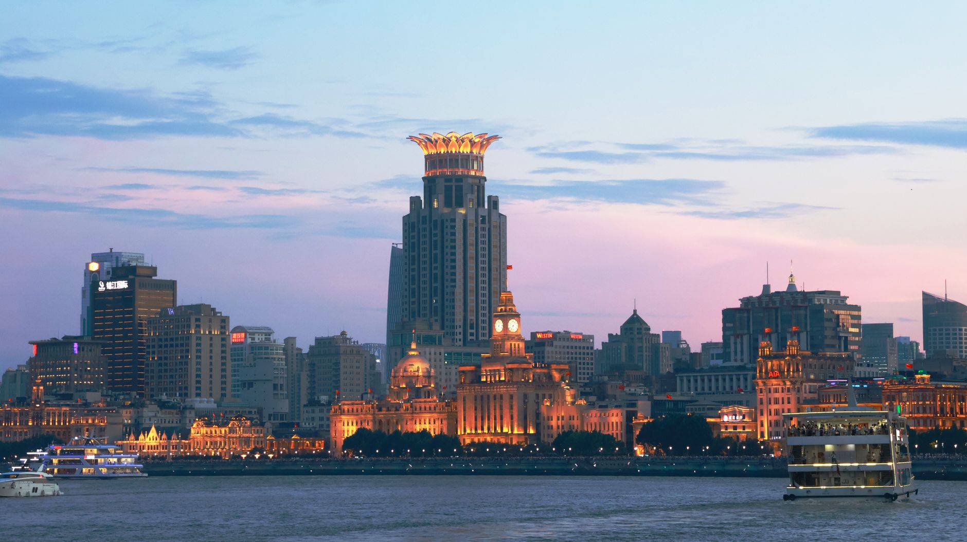 Panorama of the Shanghai skyline and the Huangpu River lit up at twilight