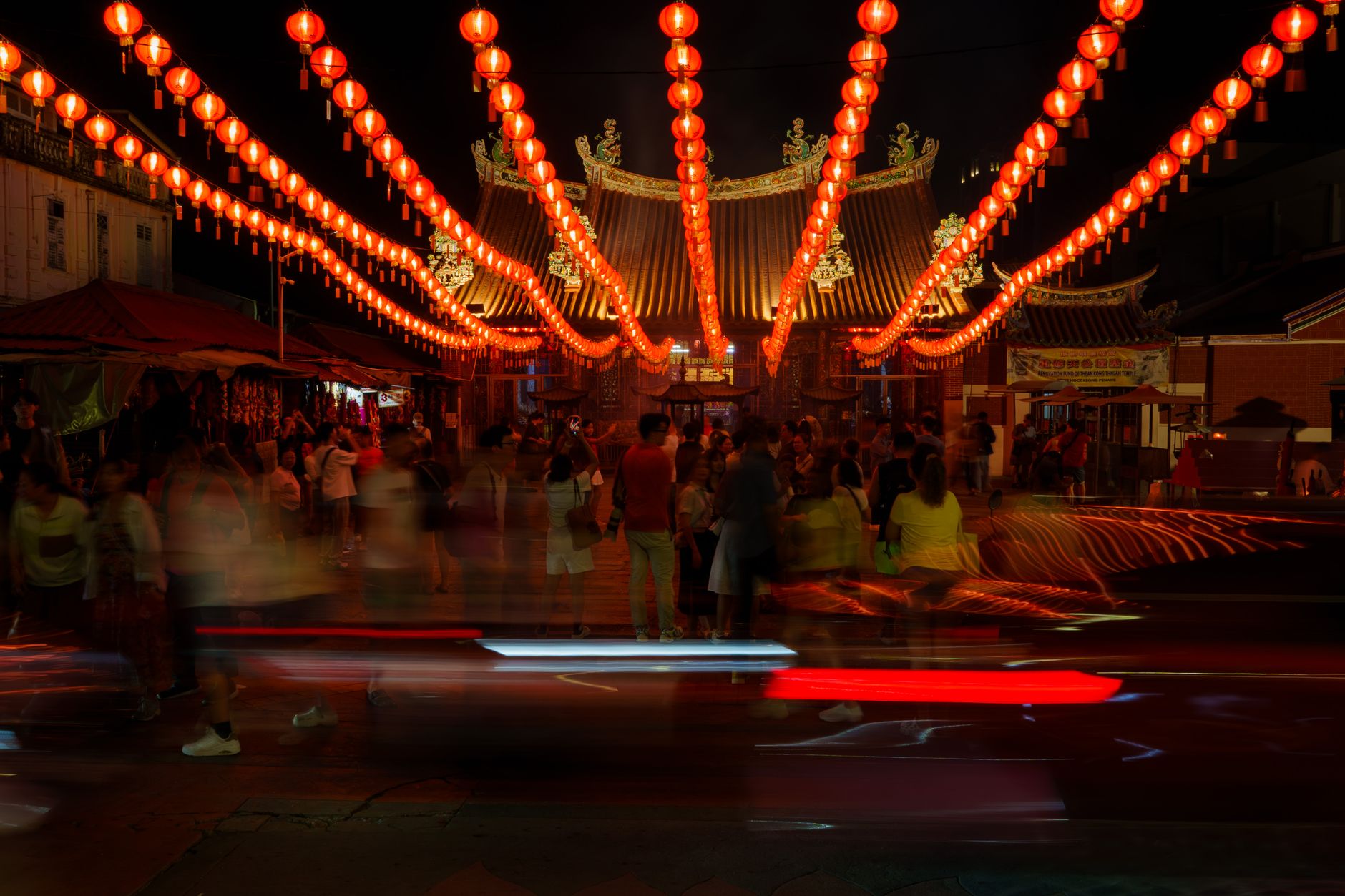Red lanterns lighting a night market street of traditional shopfronts