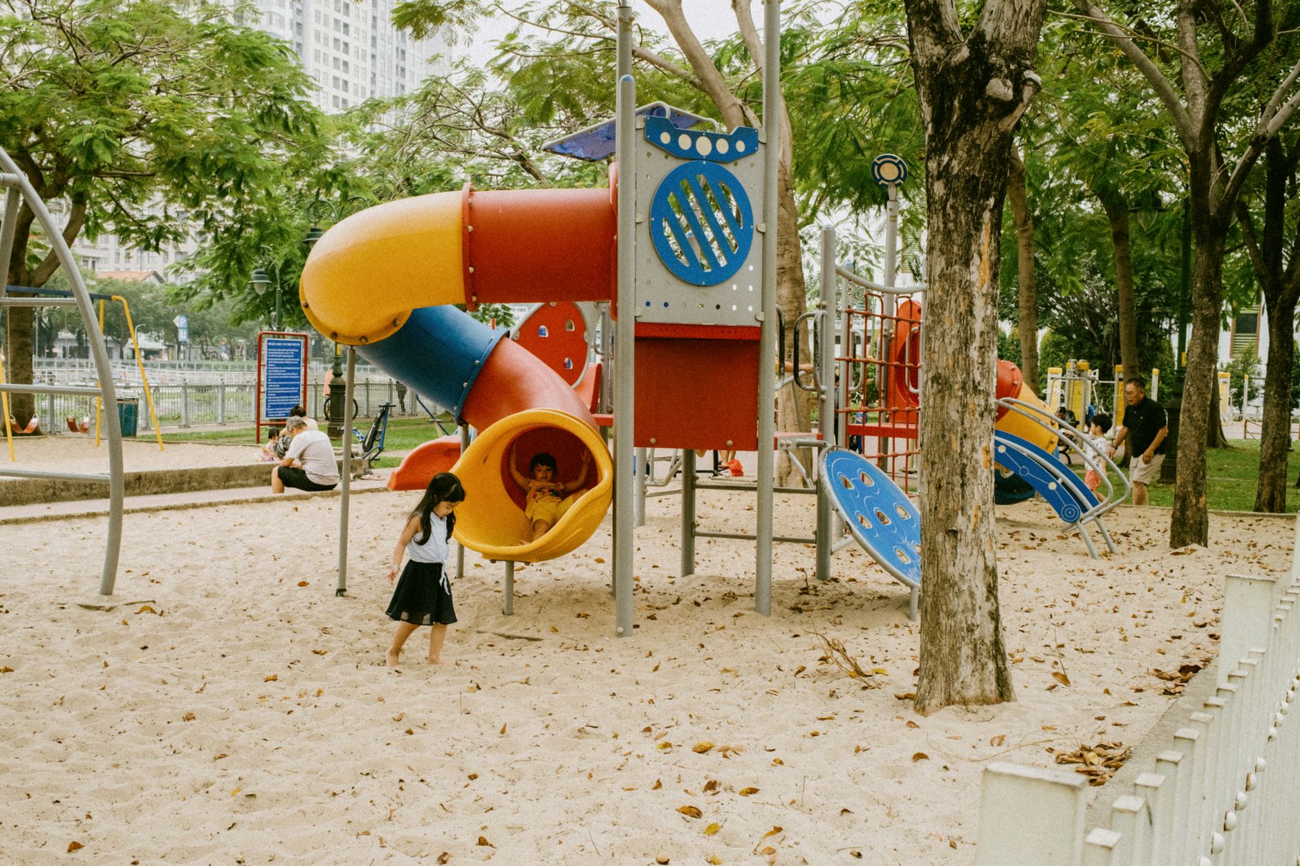 Small children climbing on slides and play structures in a public park playground