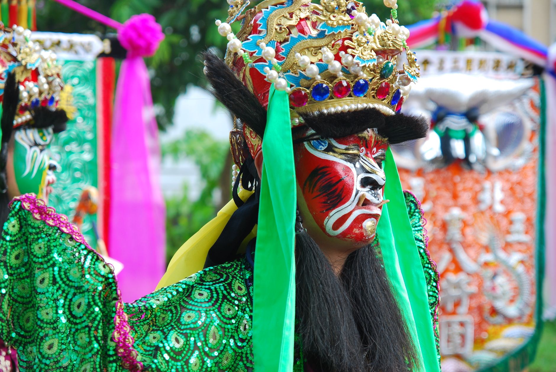 A traditional Chinese opera performer in painted face makeup and an ornate headdress