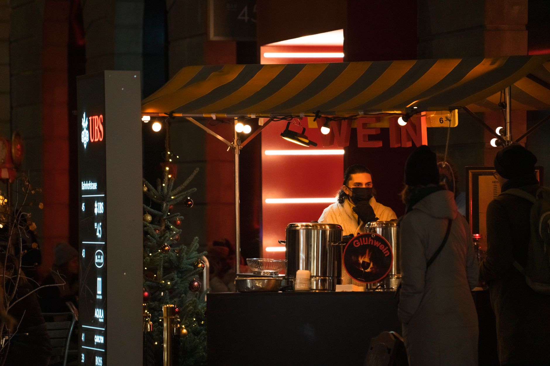 A night-time Christmas market stall serving hot mulled wine, the format Shanghai stages at the Bund and Jing an in December