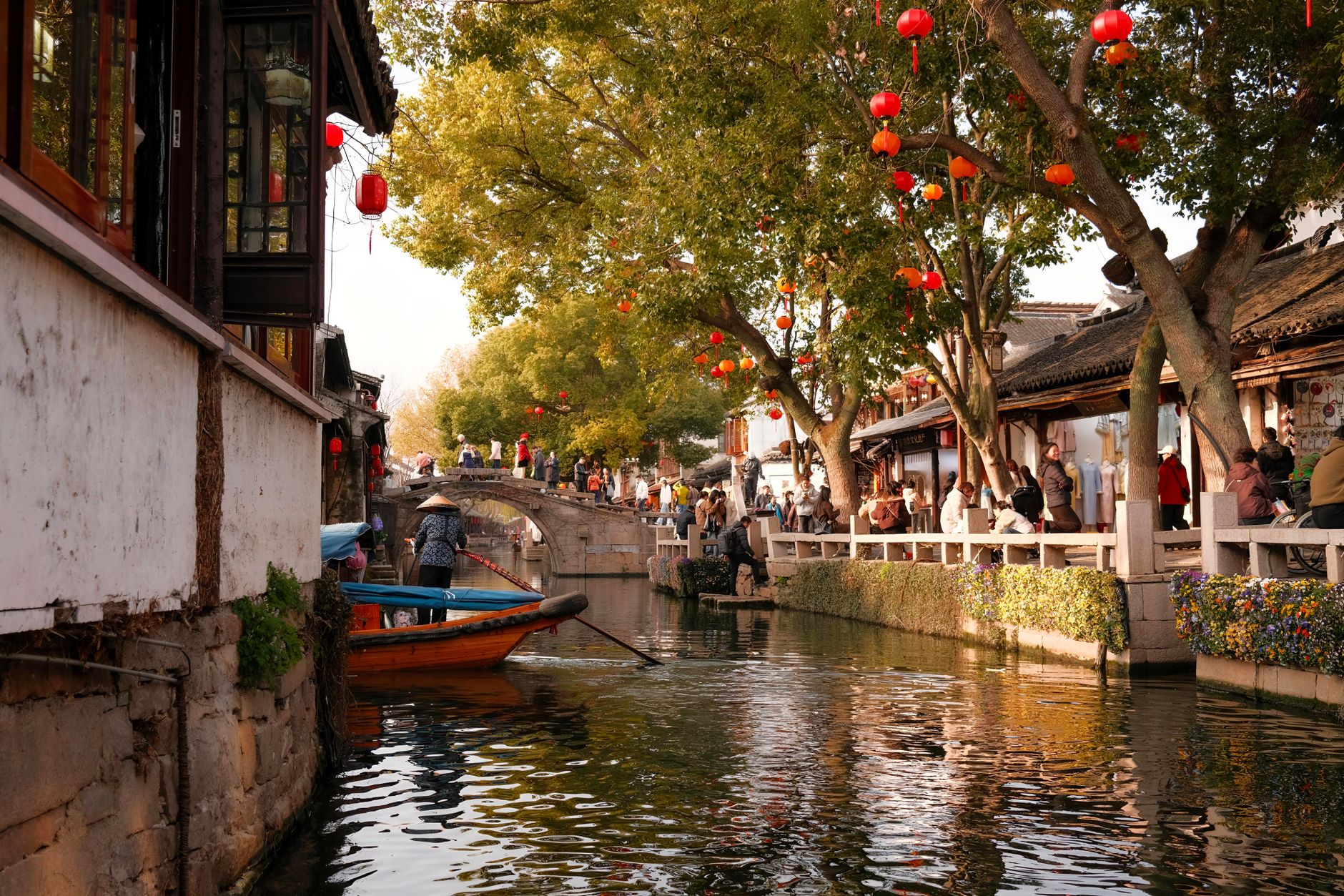 Canal lined with red lanterns and low tiled houses in Suzhou old town