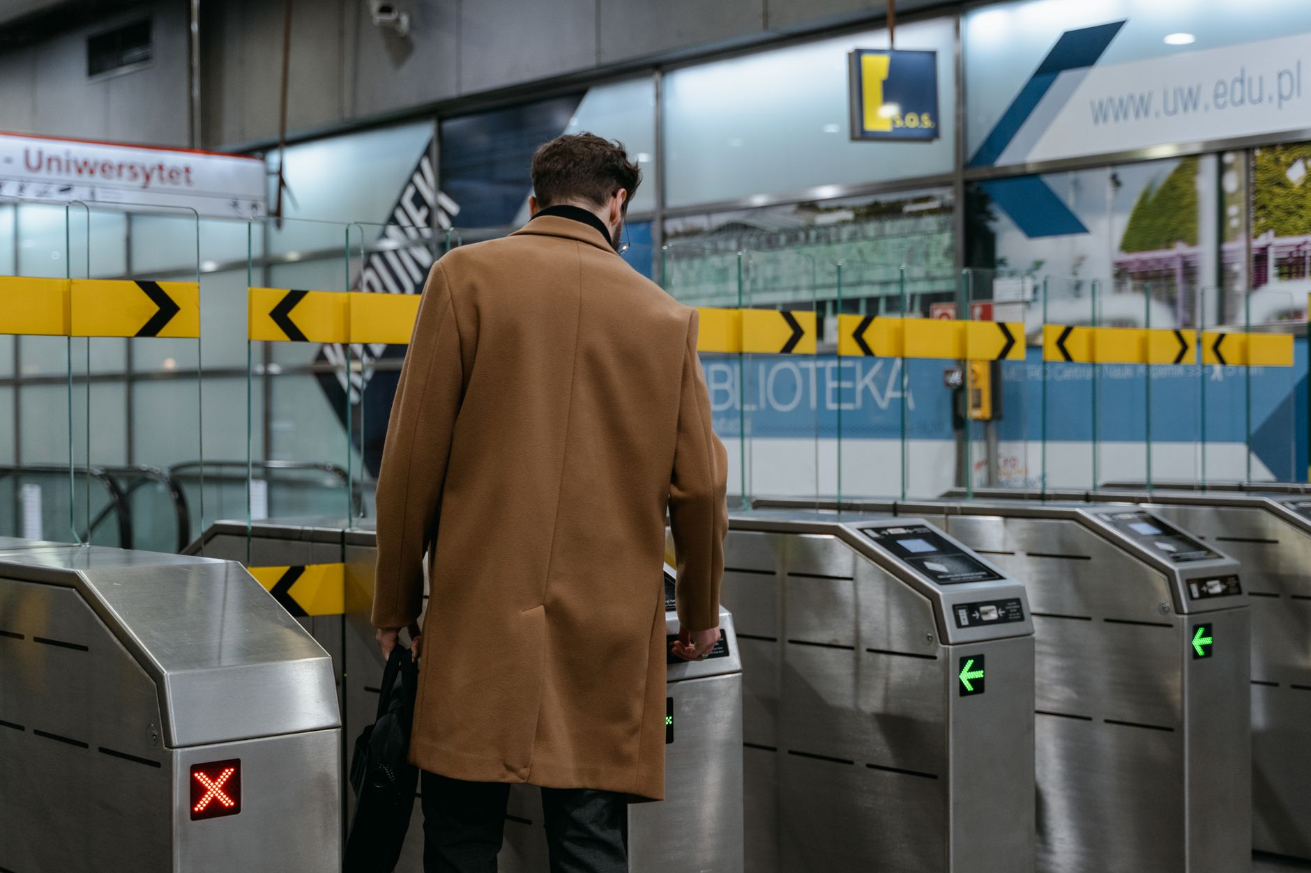 A commuter passing through metro ticket gates after tapping at the reader