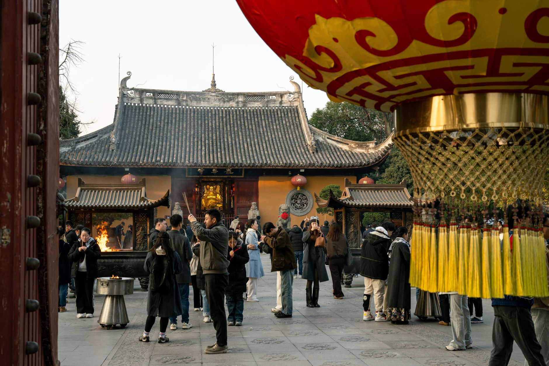Visitors in the courtyard of a Shanghai temple on a bright day