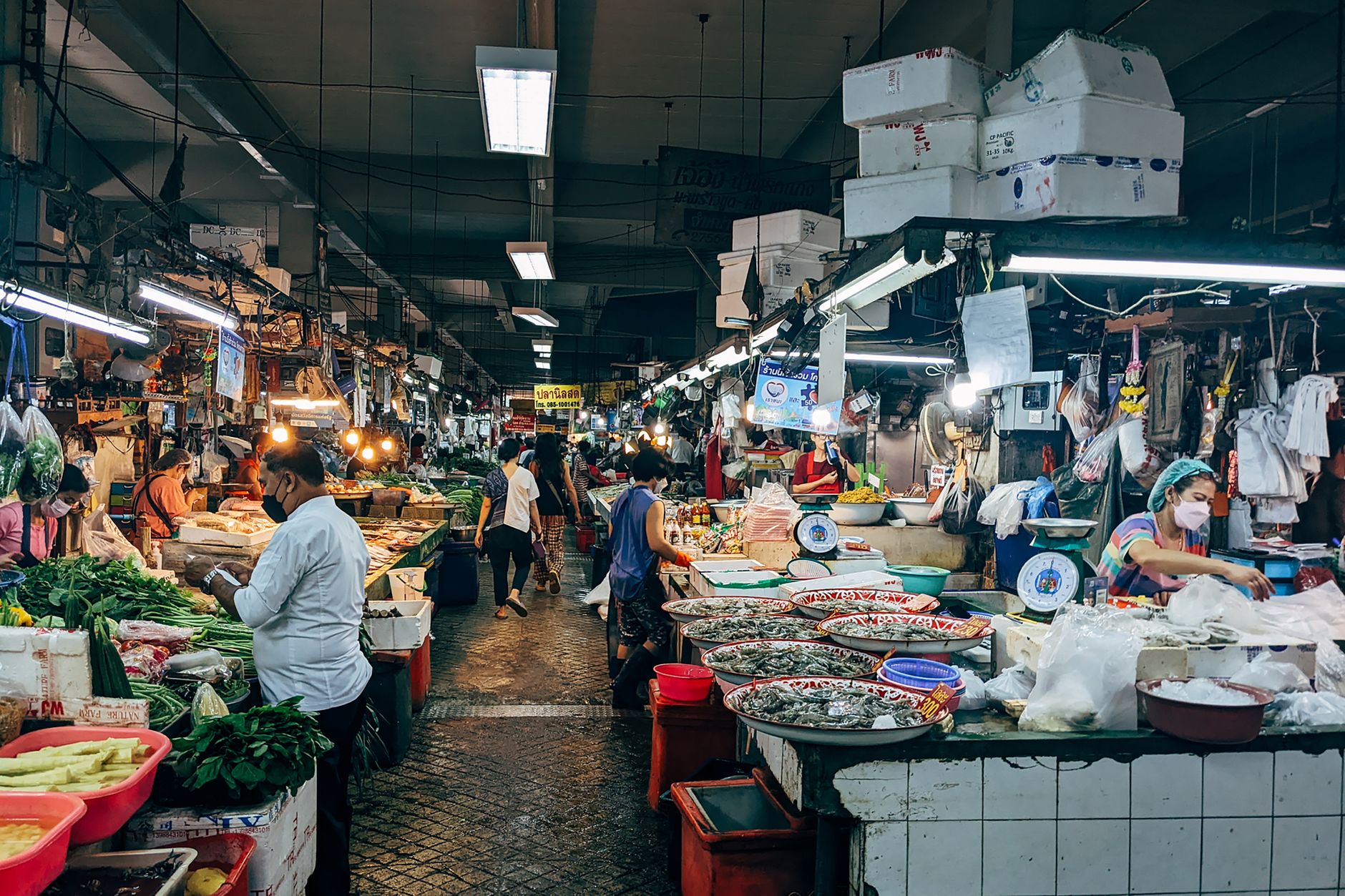 Vendors selling fresh vegetables and seafood inside a covered wet market in Shanghai