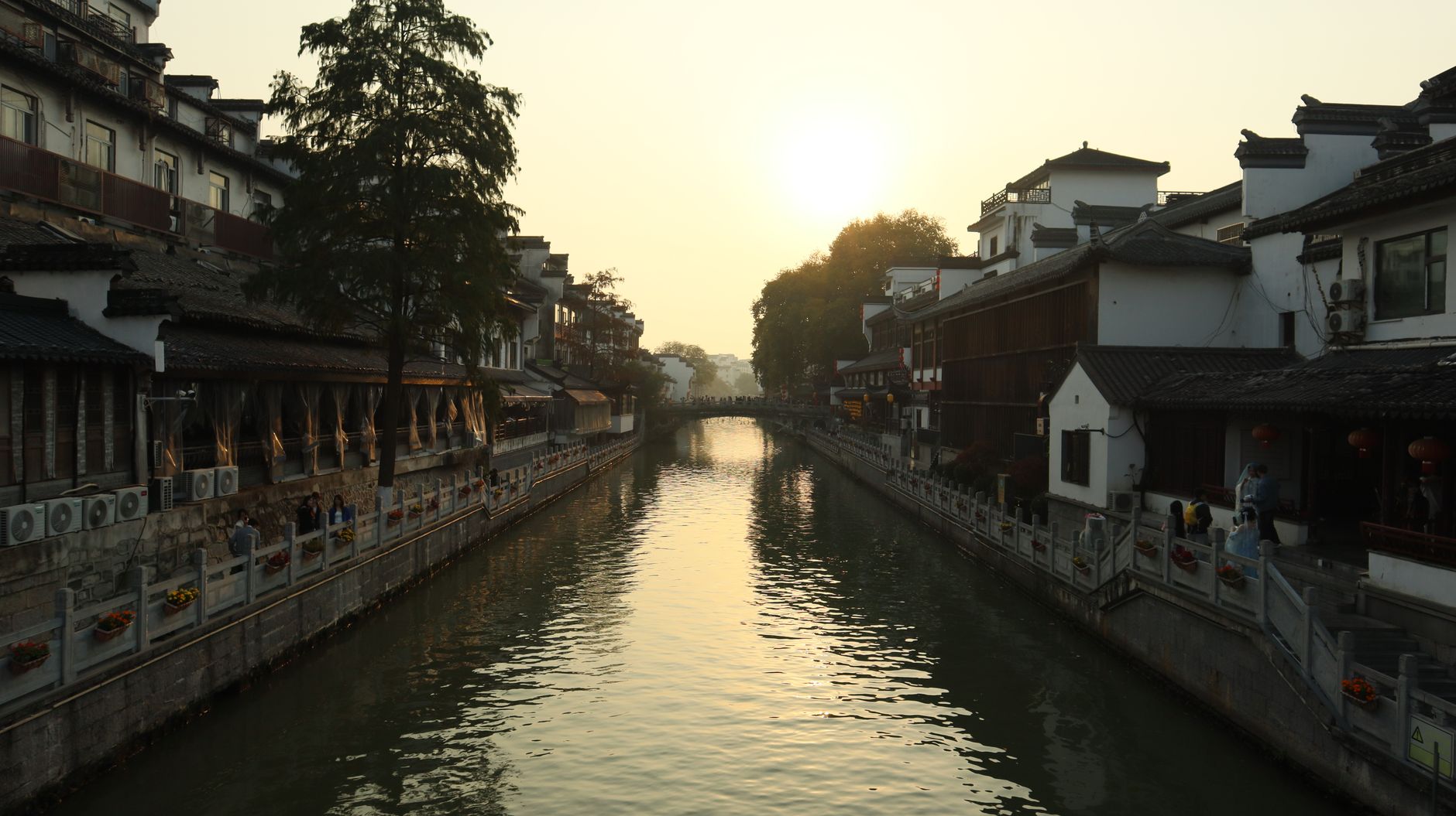 A water town canal at sunset with historic buildings along both banks