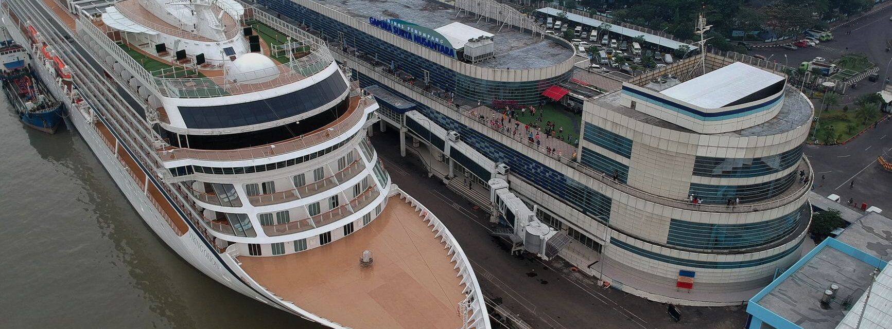 A large cruise ship alongside an international cruise terminal with the gangway rigged