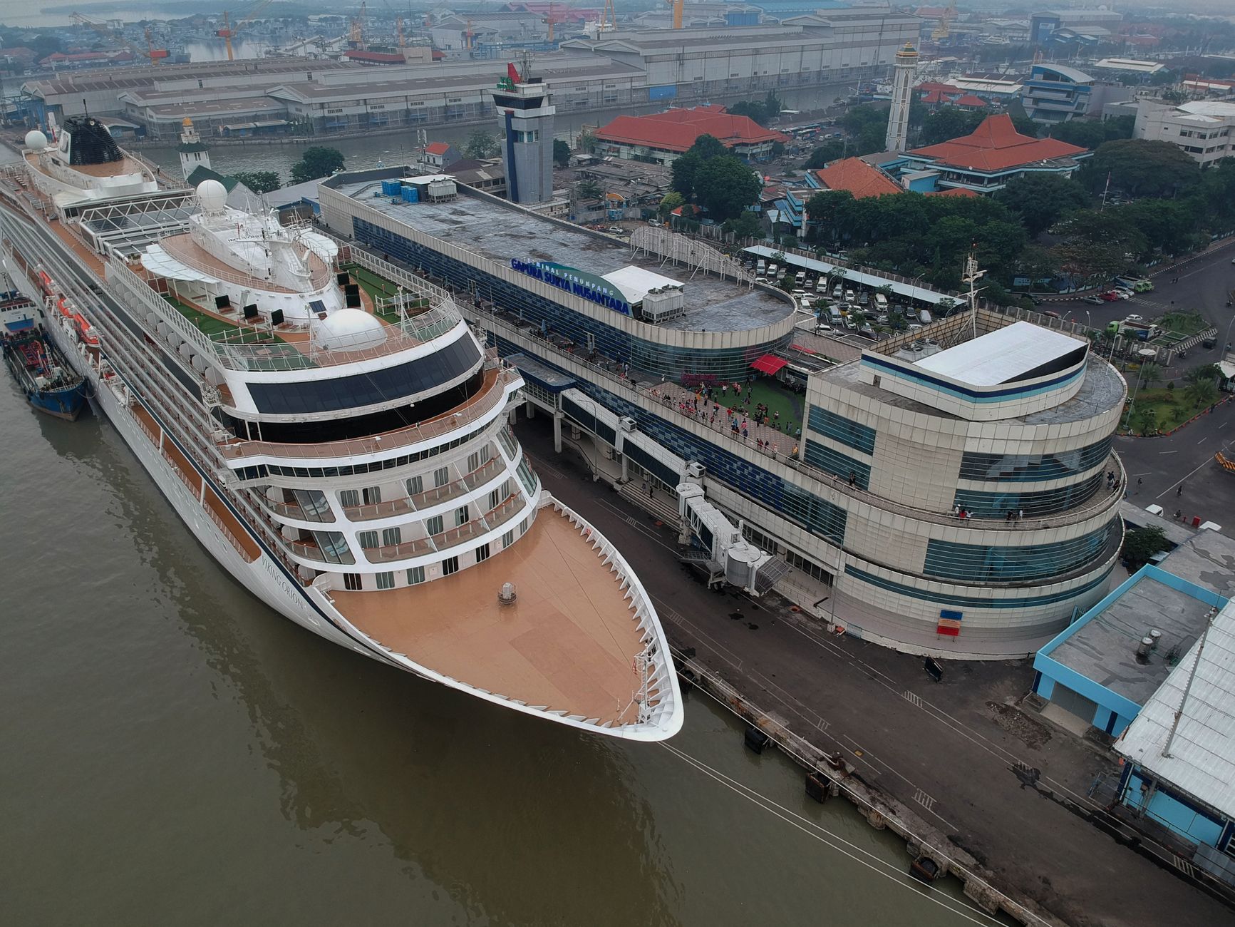 A large cruise ship alongside a dedicated international cruise terminal with the gangway rigged