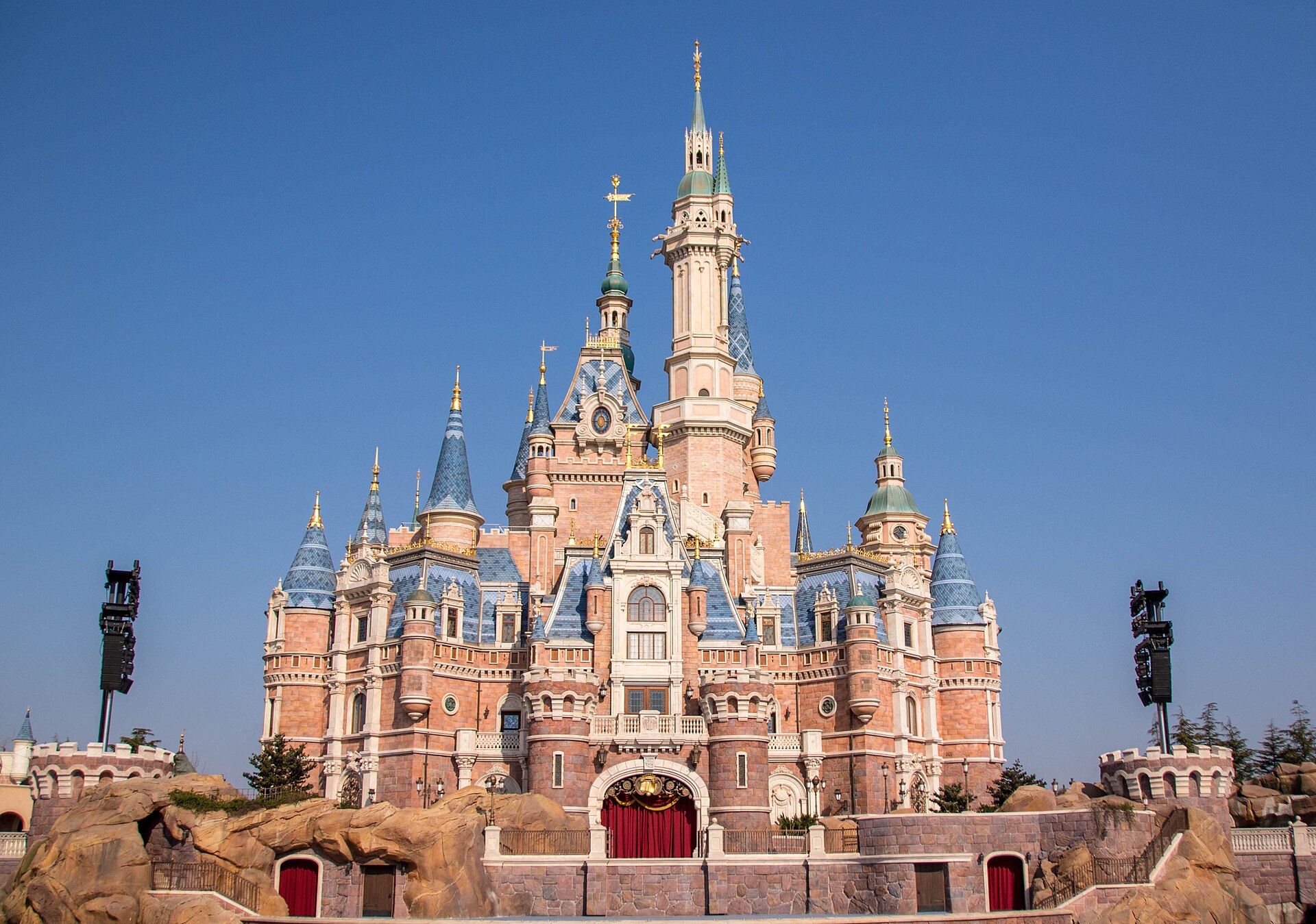 The Enchanted Storybook Castle at Shanghai Disneyland under a clear blue sky